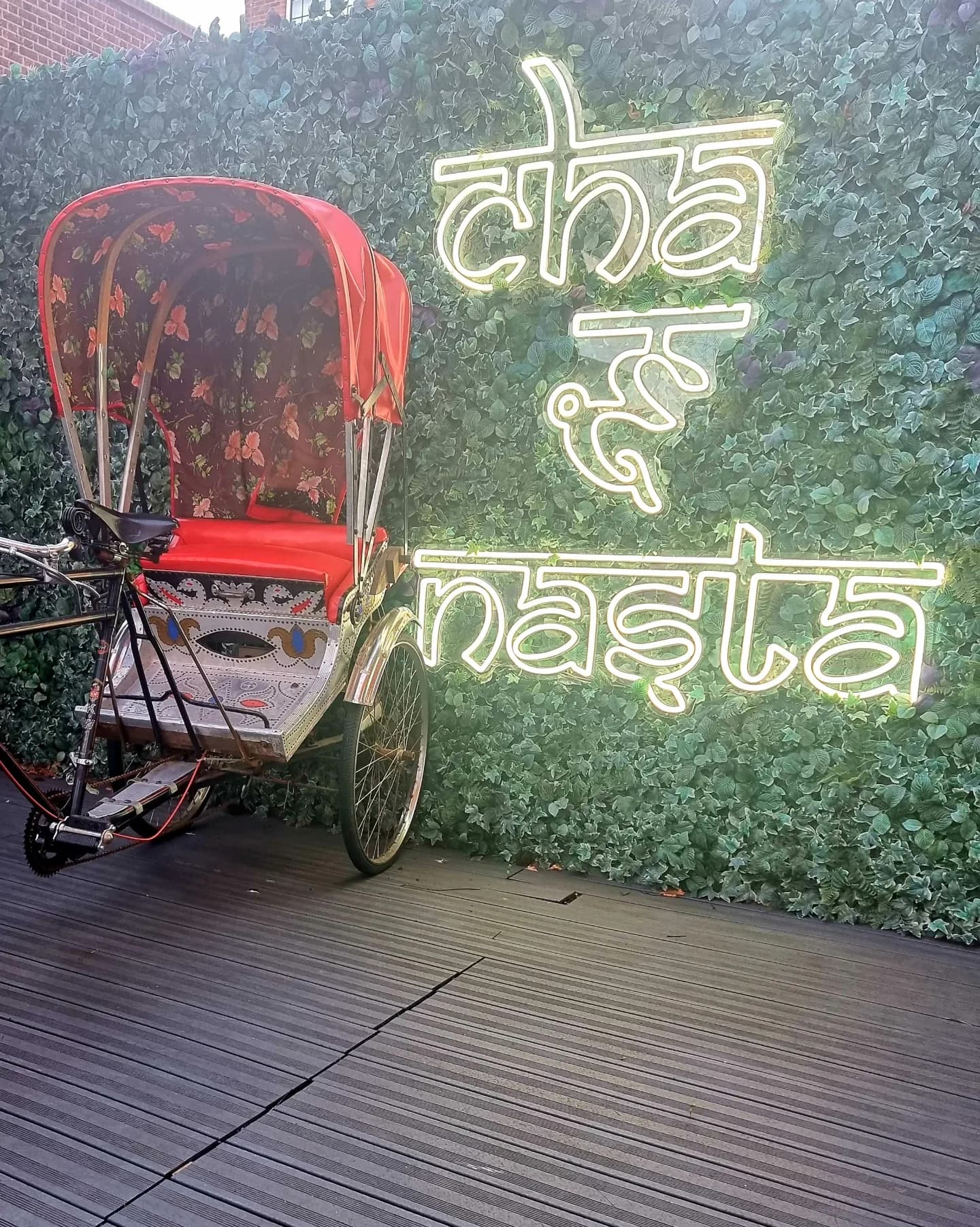 Rickshaw and neon sign in the garden room